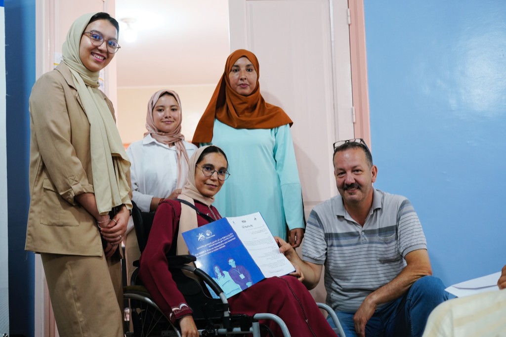 assurif project beneficiary holding her support document